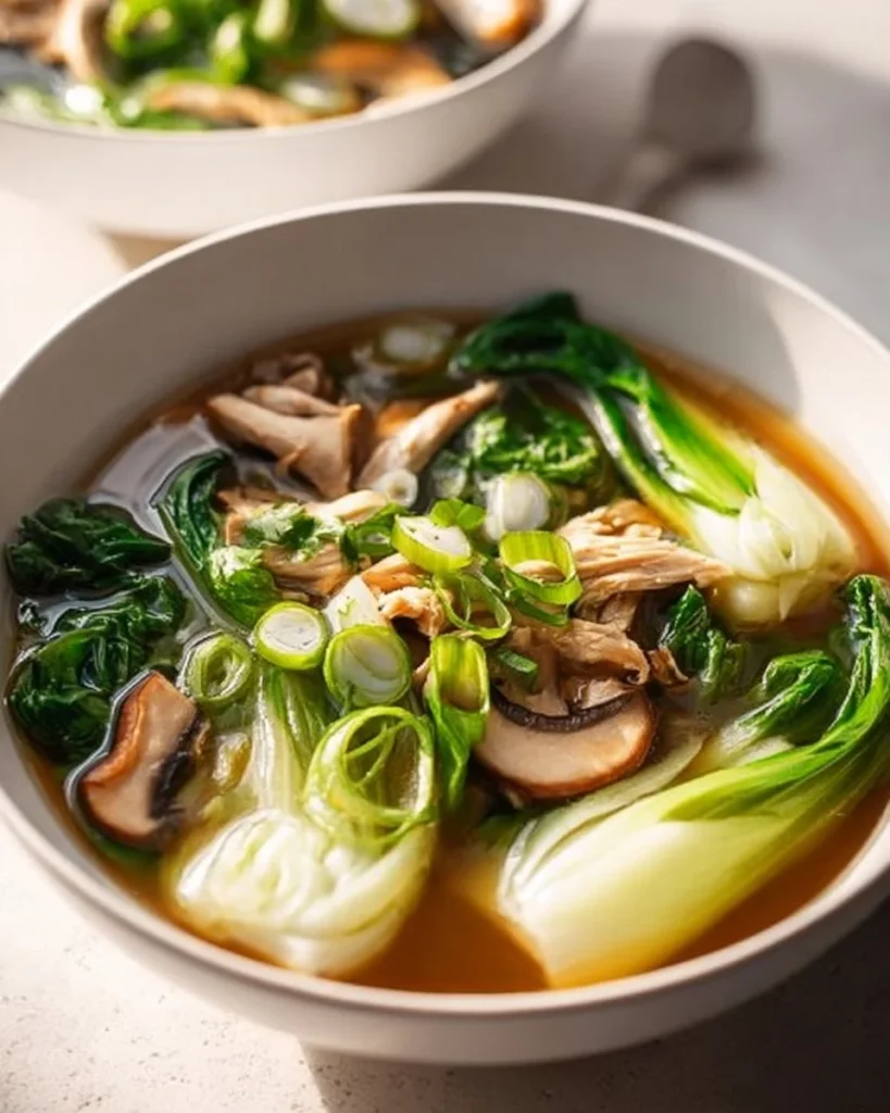 Bok Choy Chicken Soup in a bowl garnished with fresh herbs
