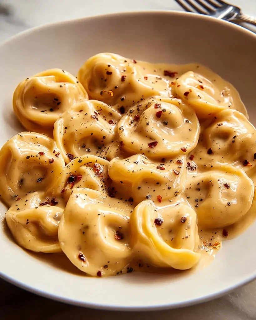 Creamy roast garlic lemon pasta sauce in a bowl with herbs and pasta